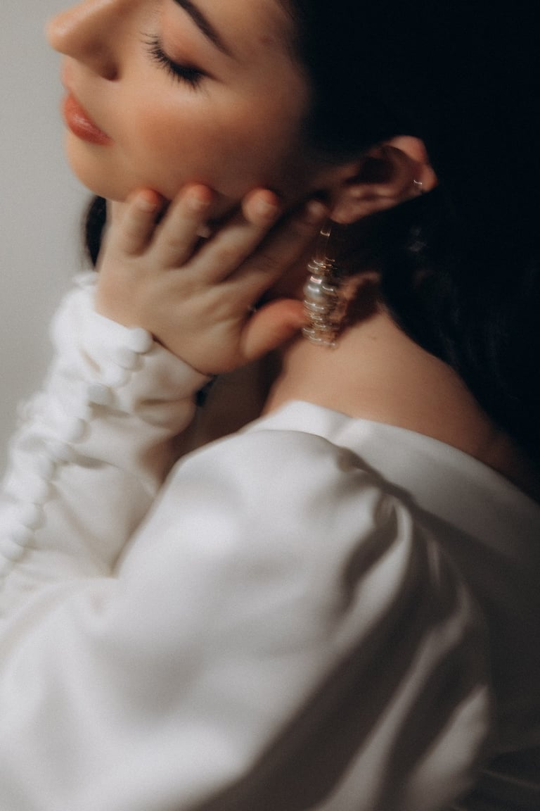 a woman with a white shirt and earrings