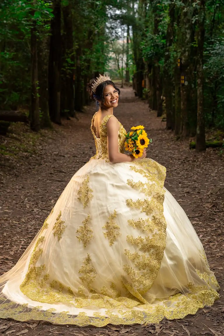 Retrato editorial de quinceañera en bosque de Quito con vestido dorado. Iluminación cinematográfica premium