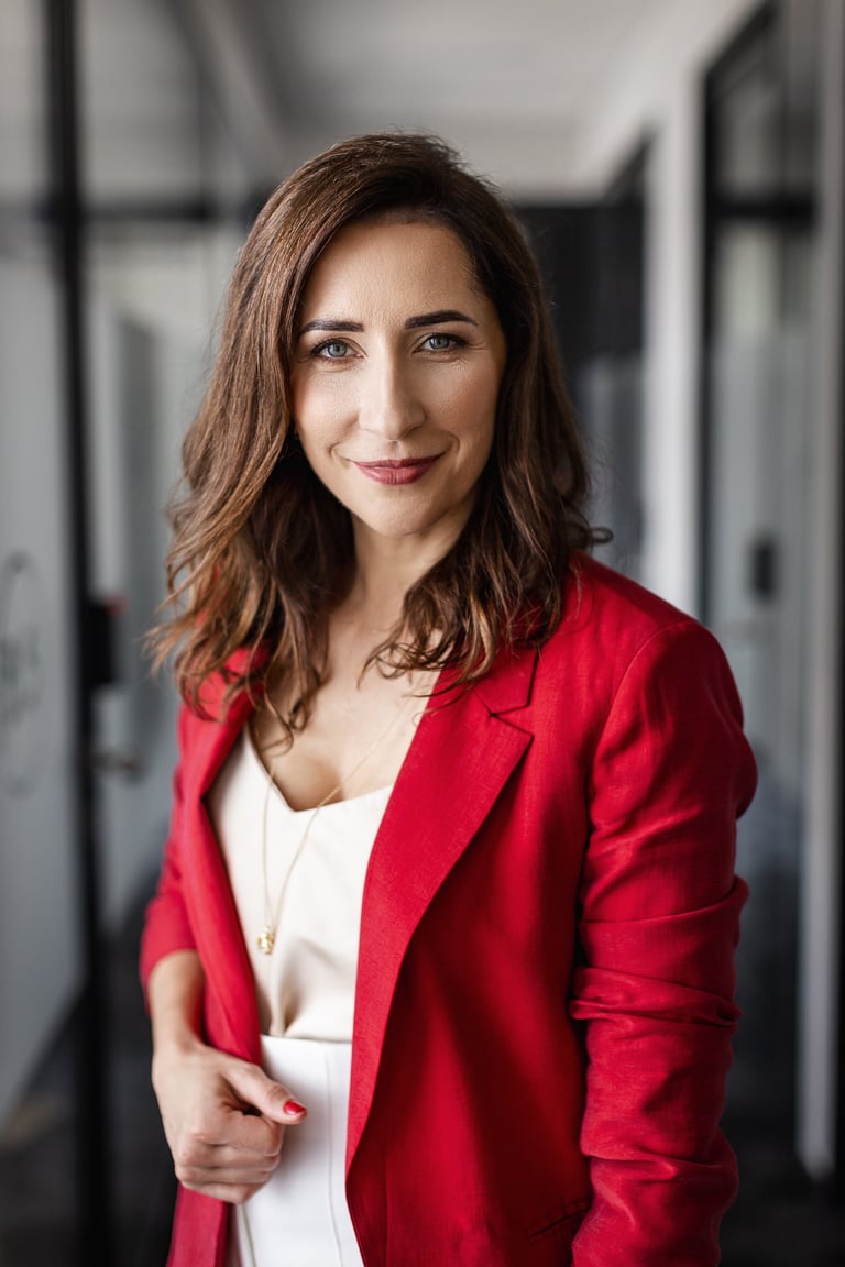 a woman in a red jacket and white top