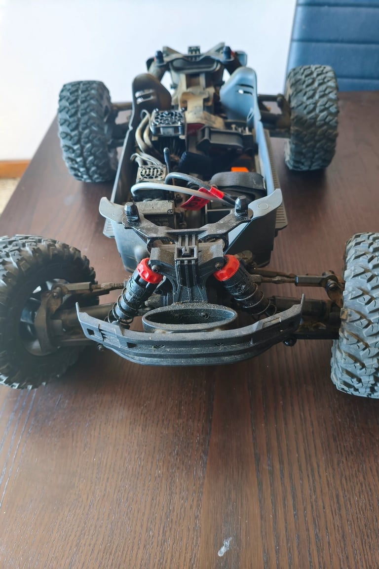 Review de ARRMA Big Rock 3S BLX detalhando os braços de suspensão e o para-choques frontal interno.