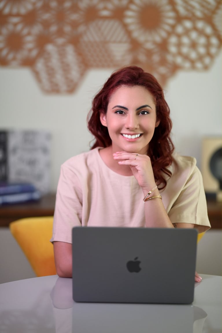 Psicóloga Palloma D'Andrade sorrindo enquanto trabalha com terapia online