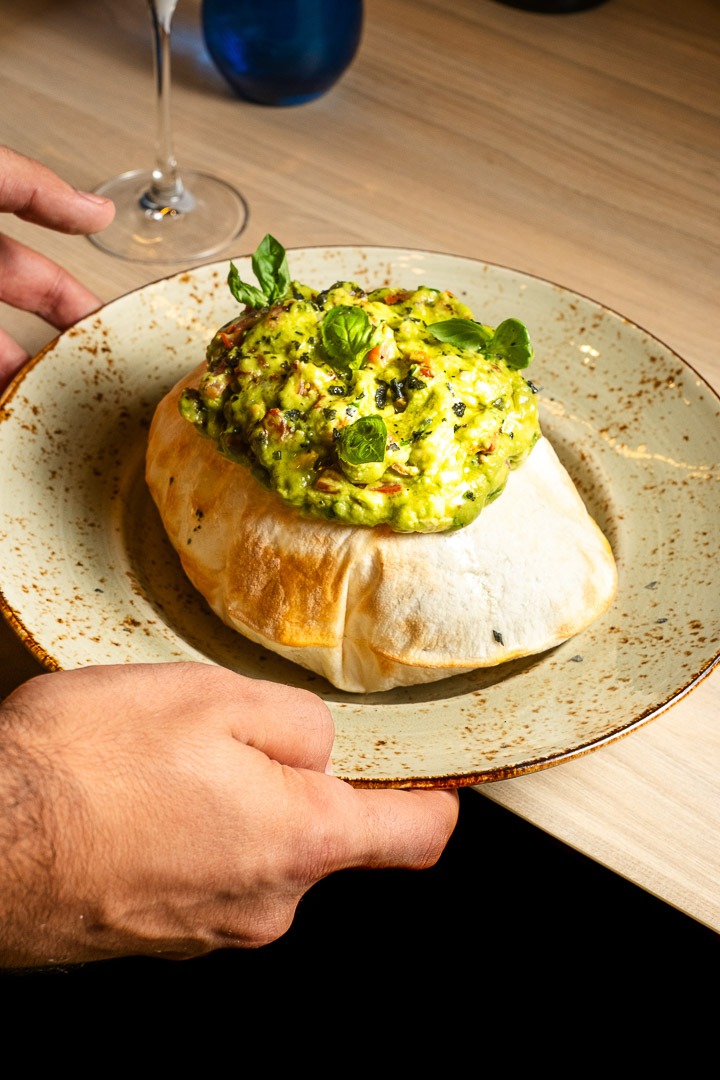 a person holding a plate with a bowl of food