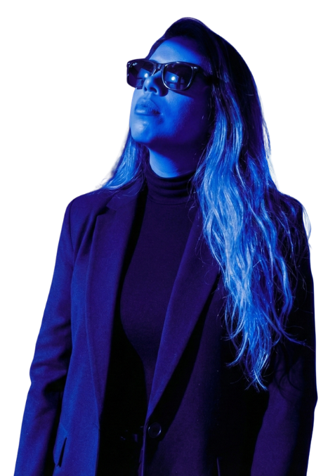 Consultora en marketing digital con blazer y gafas de sol bajo iluminación azul neón.