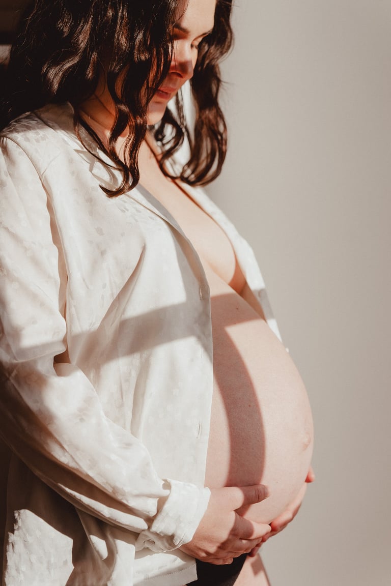 Photo de femme enceinte avec chemise blanche lumière douce en intérieur