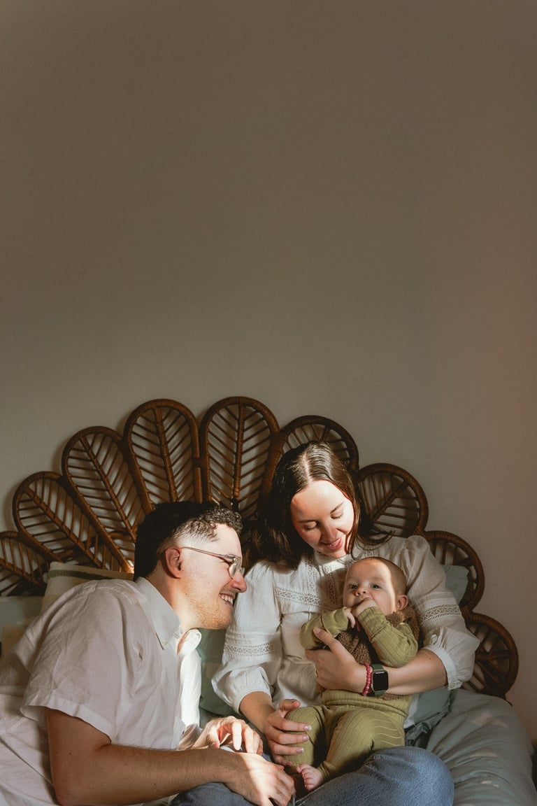 plan large de deux adultes et un bébé assis sur un lit