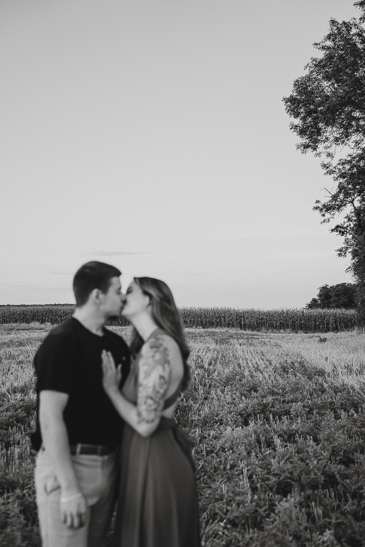 plan large d'une couple en noir et blanc qui s'embrasse premier plan flou paysage net