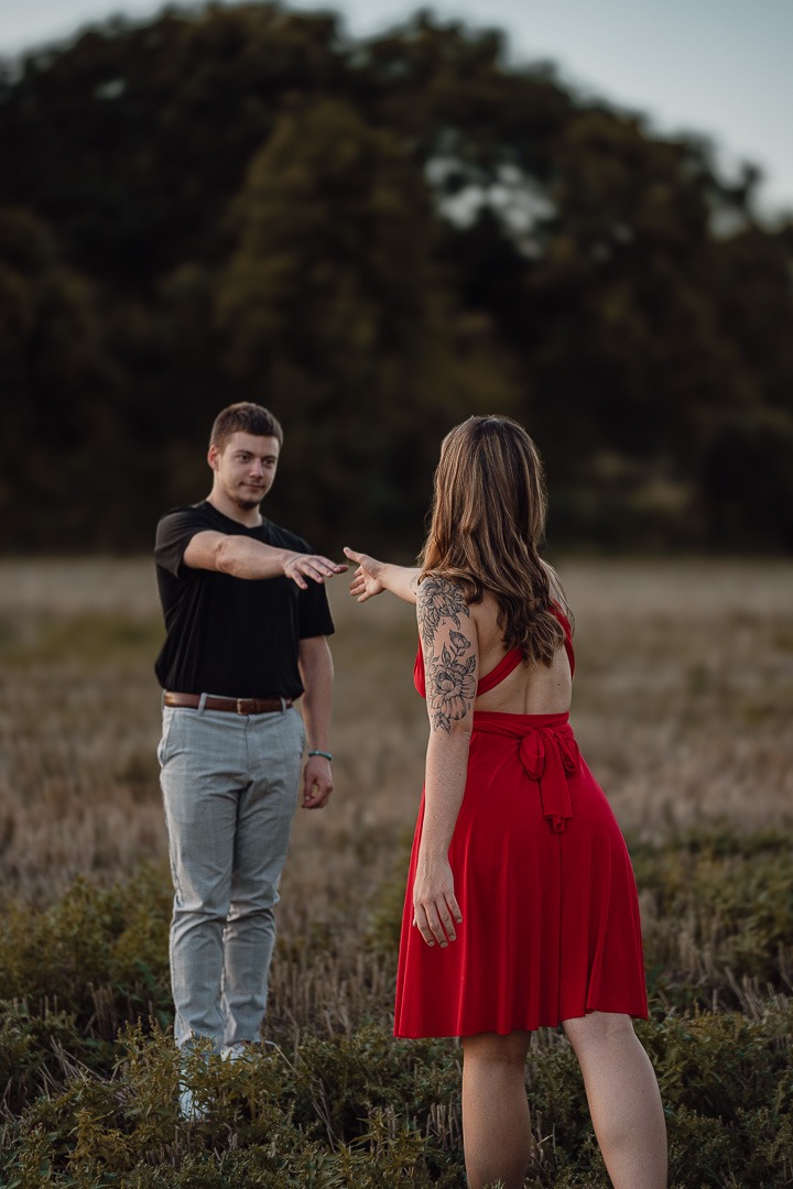 portrait de couple se tendant la main dans un champs