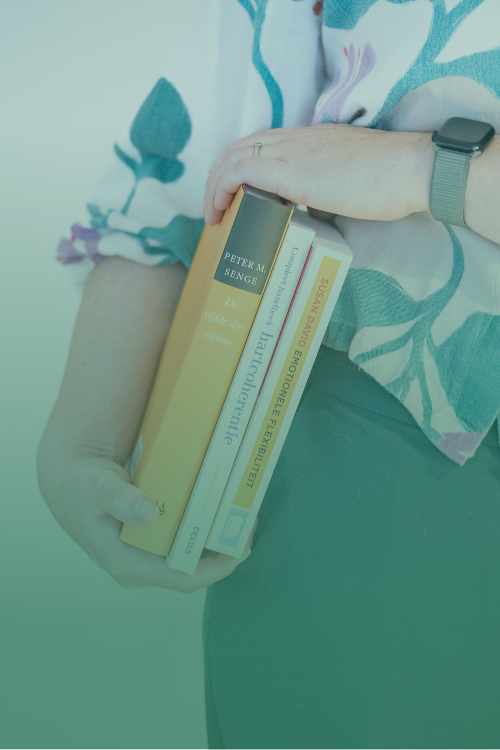 Iris Van Belleghem met boeken 'hartcoherentie', 'emotionele flexibiliteit' en 'De vijfde discipline'