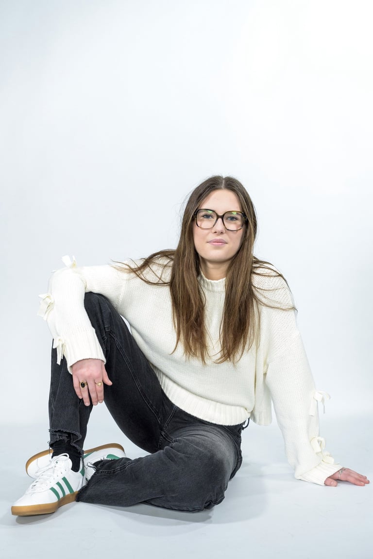 a woman in glasses and a white sweater