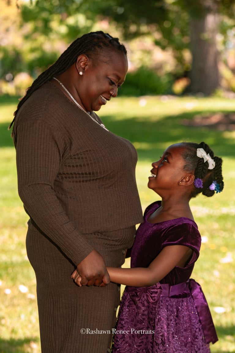 a woman in a purple dress standing next to a young girl in a family Portrait