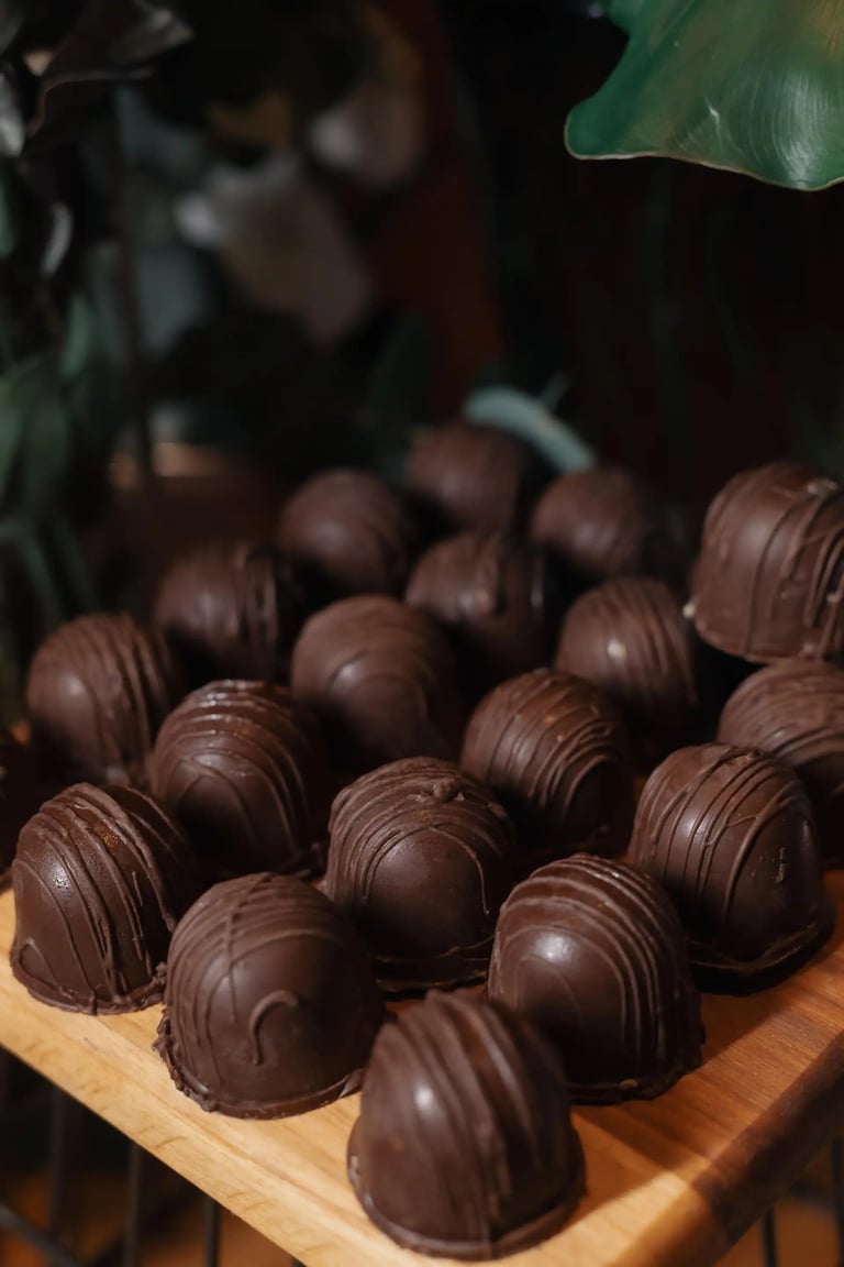 Uma deliciosa seleção de bombons de chocolate dispostos em uma superfície de madeira, destacando a f