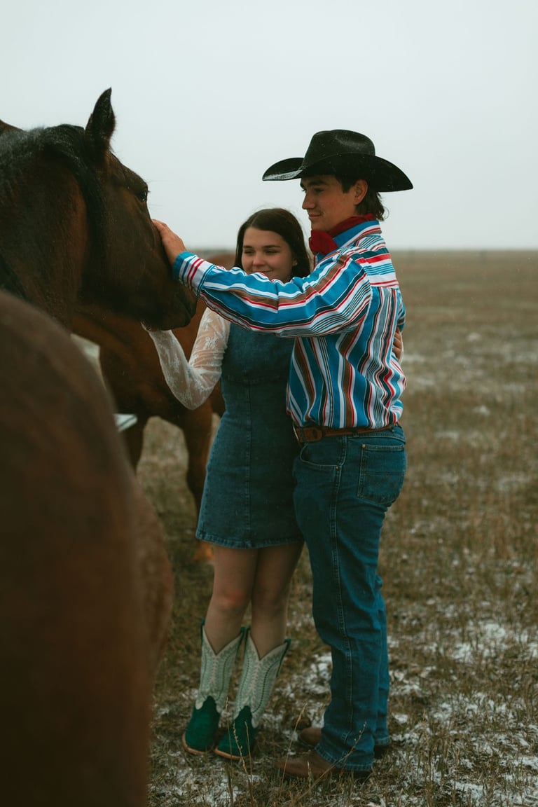 a man and woman standing in a field with horses