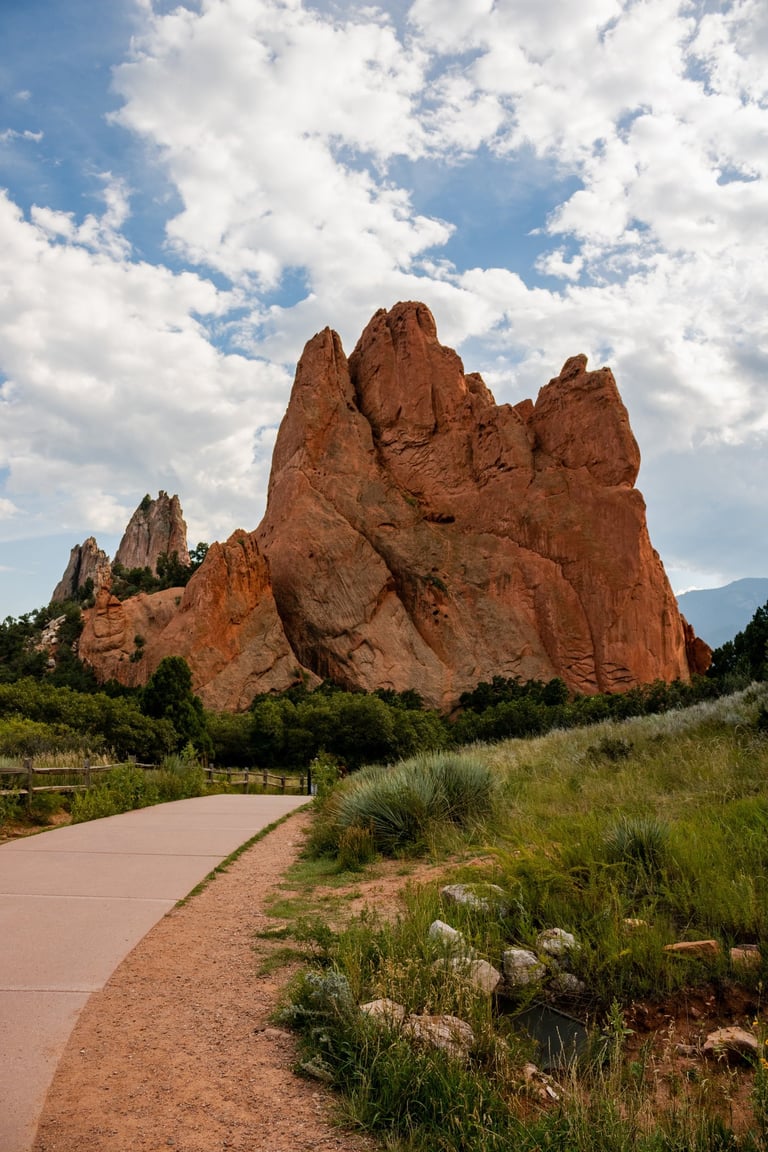 a paved path with a paved path leading to a mountain, Garden of the Gods
