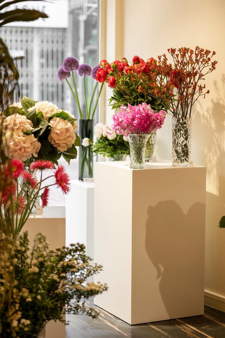 vase de fleurs en exposition sur des stèles blanche dans une boutique de fleurs dans l'aube
