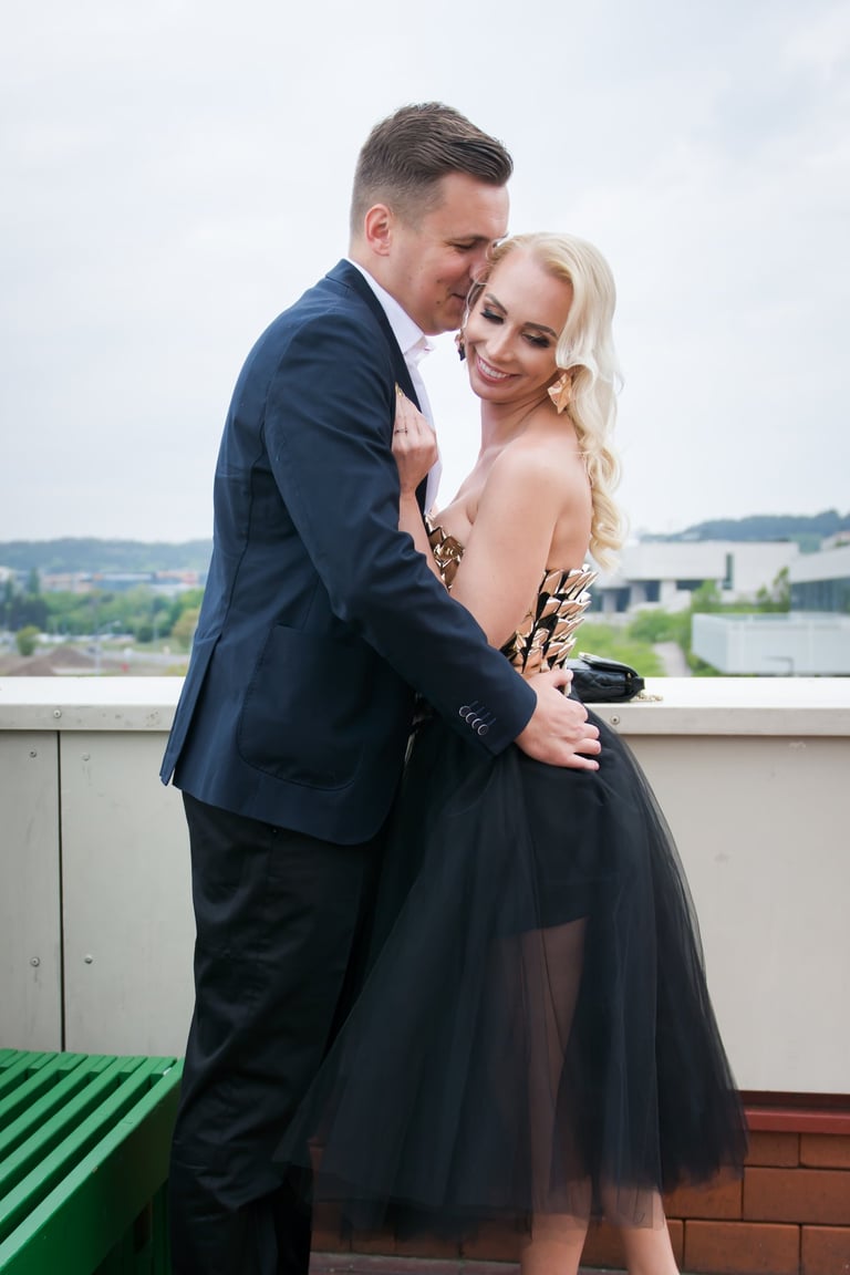 Lengvas poros flirtas, vyras apkabinęs moterį, kažką šnibžda jai į ausį 