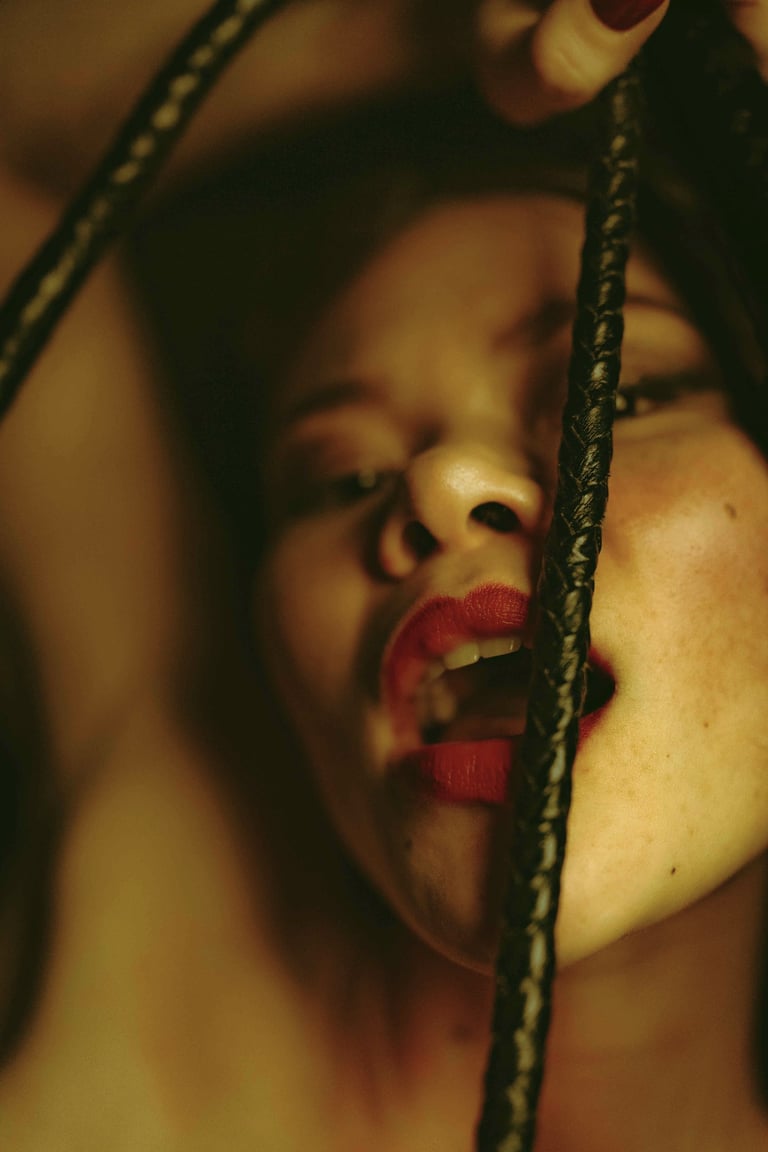a woman taken in picture playing with a black whip