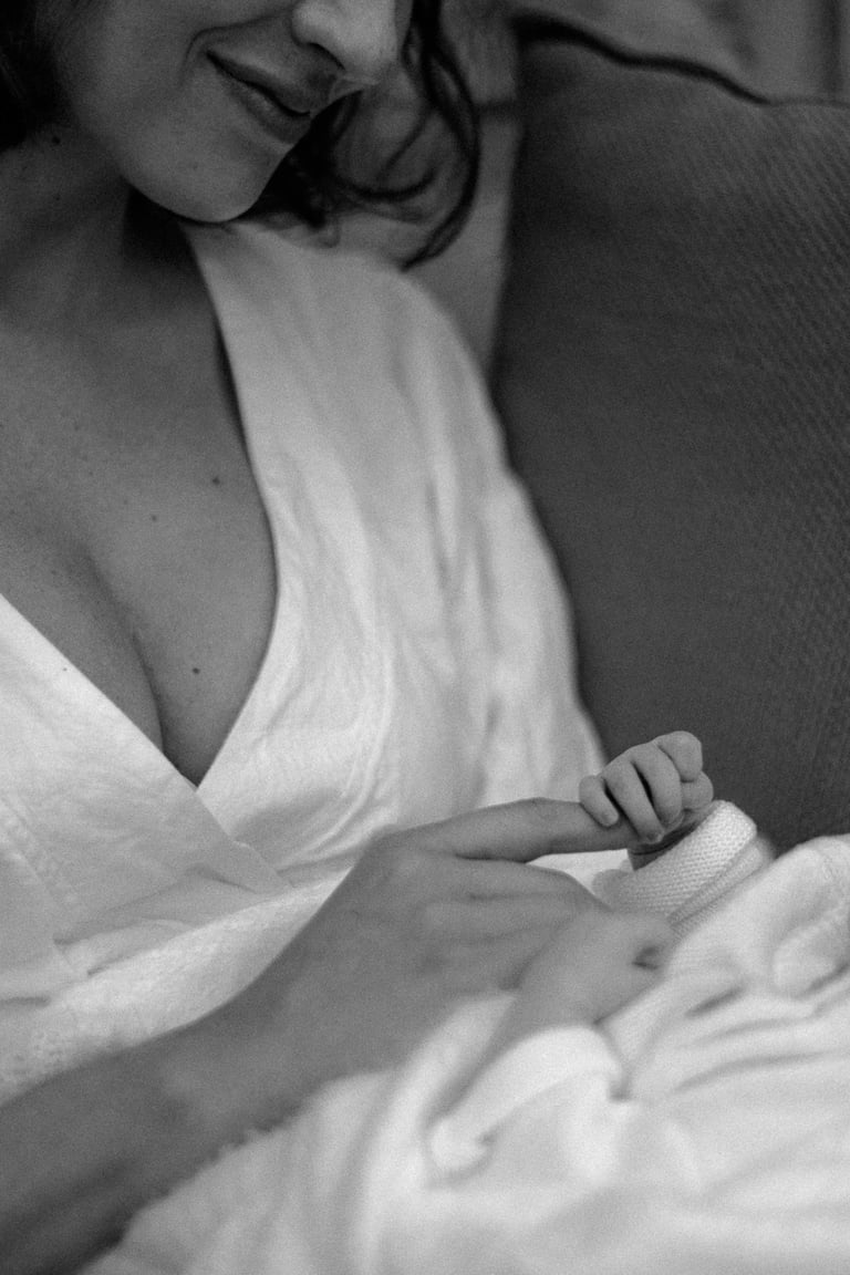 newborn baby holding mothers index finger tight in a lifestyle newborn photography session