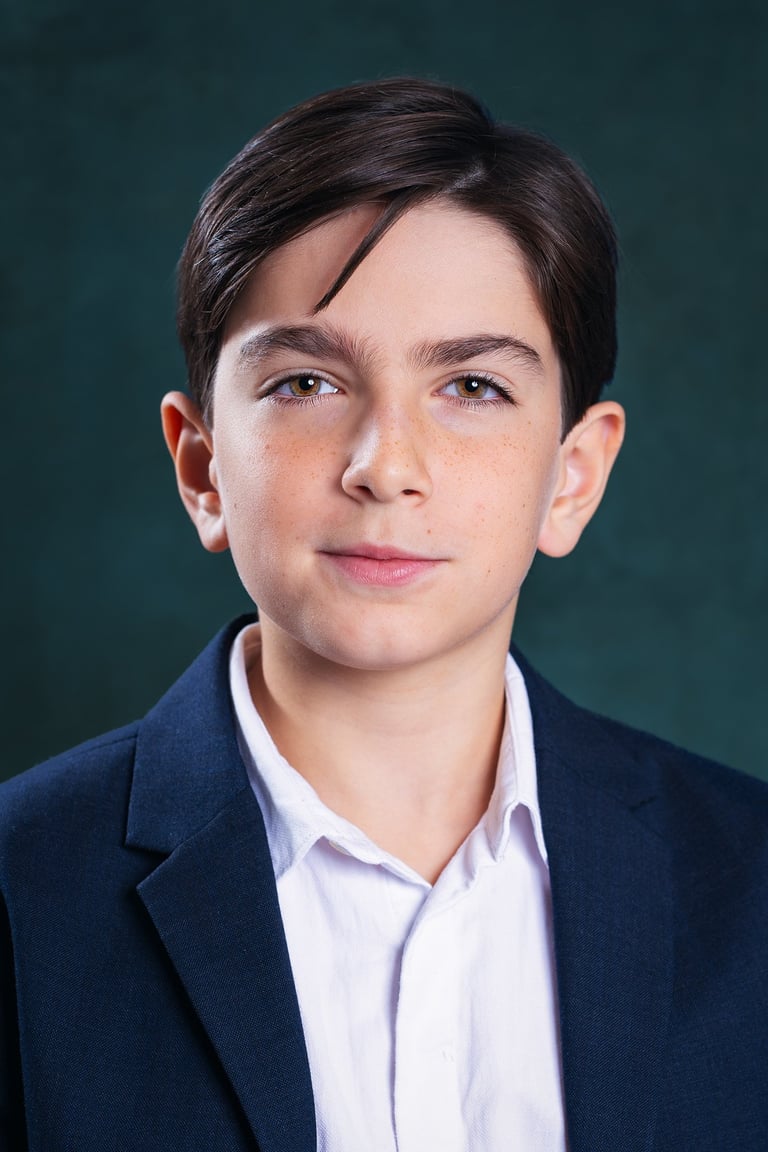 a young boy with a white shirt and a blue jacket