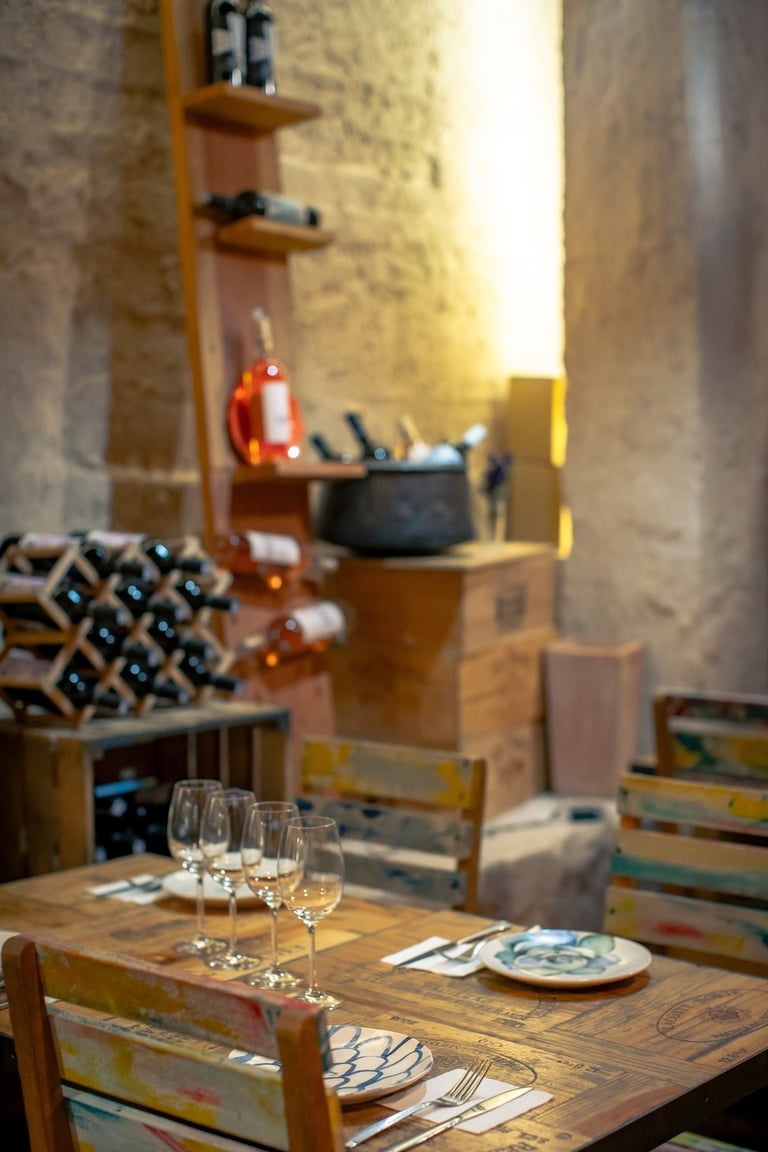 Rustic Tapastan dining room with wooden tables, wine racks, and elegant glassware.