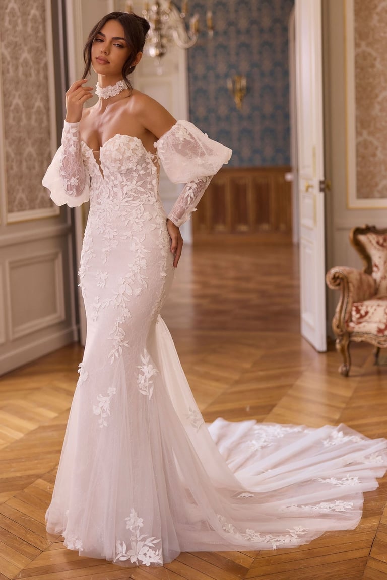 Elegant bride wearing an off-the-shoulder mermaid wedding dress with floral lace and puff sleeves.