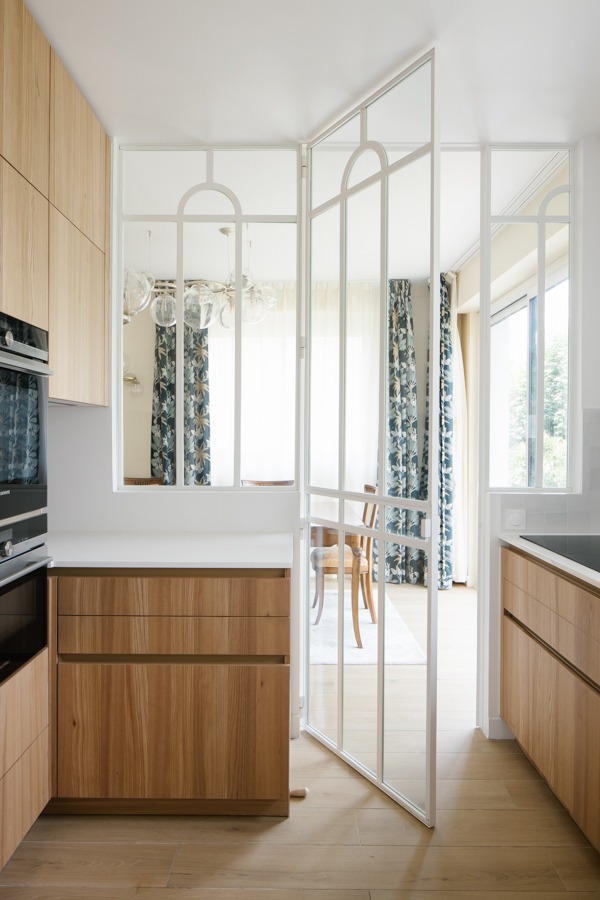 a kitchen with a large window and a table with chairs