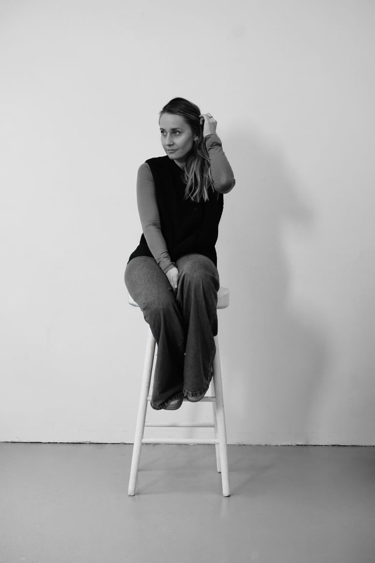black and white woman sitting on the chair holding her hair