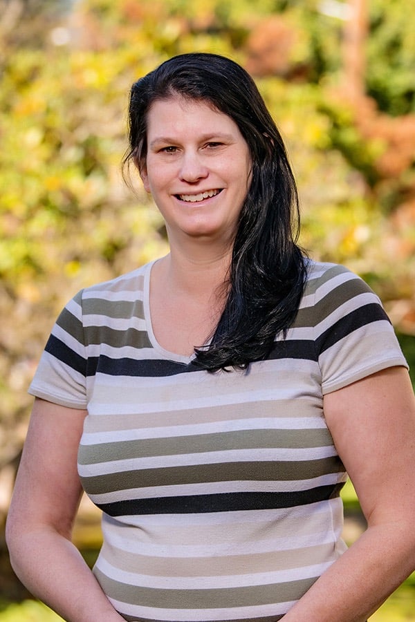 Image of Michelle smiling against background of yellow fall leaves