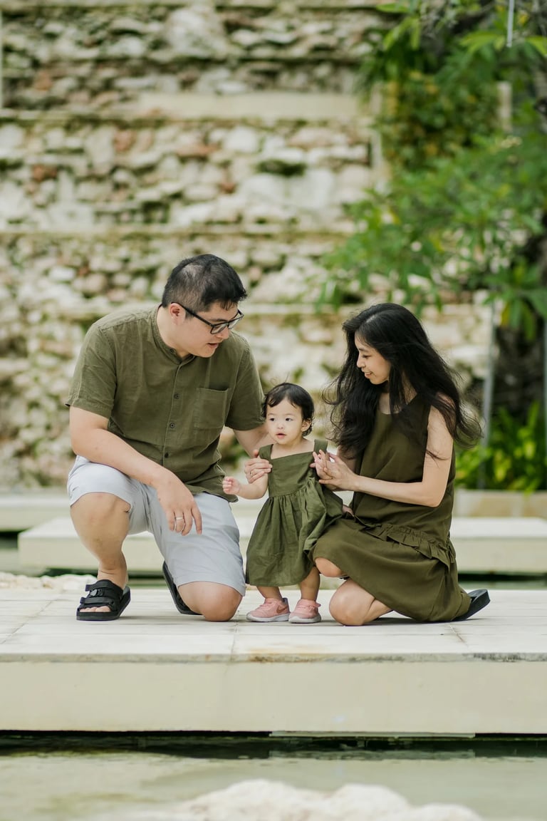 Family portrait surrounded by tropical gardens at The Apurva Kempinski Bali in Nusa Dua