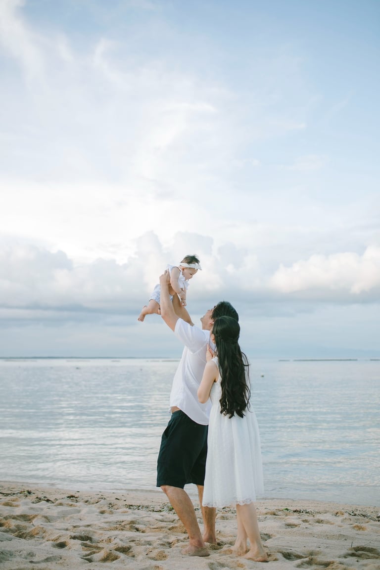 Mother holding child by the beach during family photography session at Sofitel Nusa Dua Bali