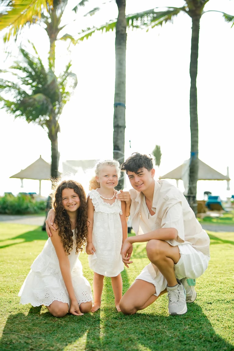 Family portrait framed by the iconic swing structure at Ayodya Resort Bali in Nusa Dua
