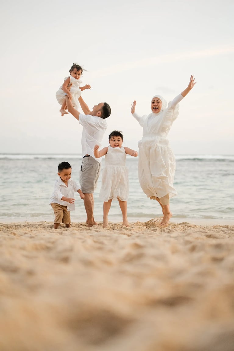 Joyful family moment captured at Melasti Beach Bali with parents and children running on the sand