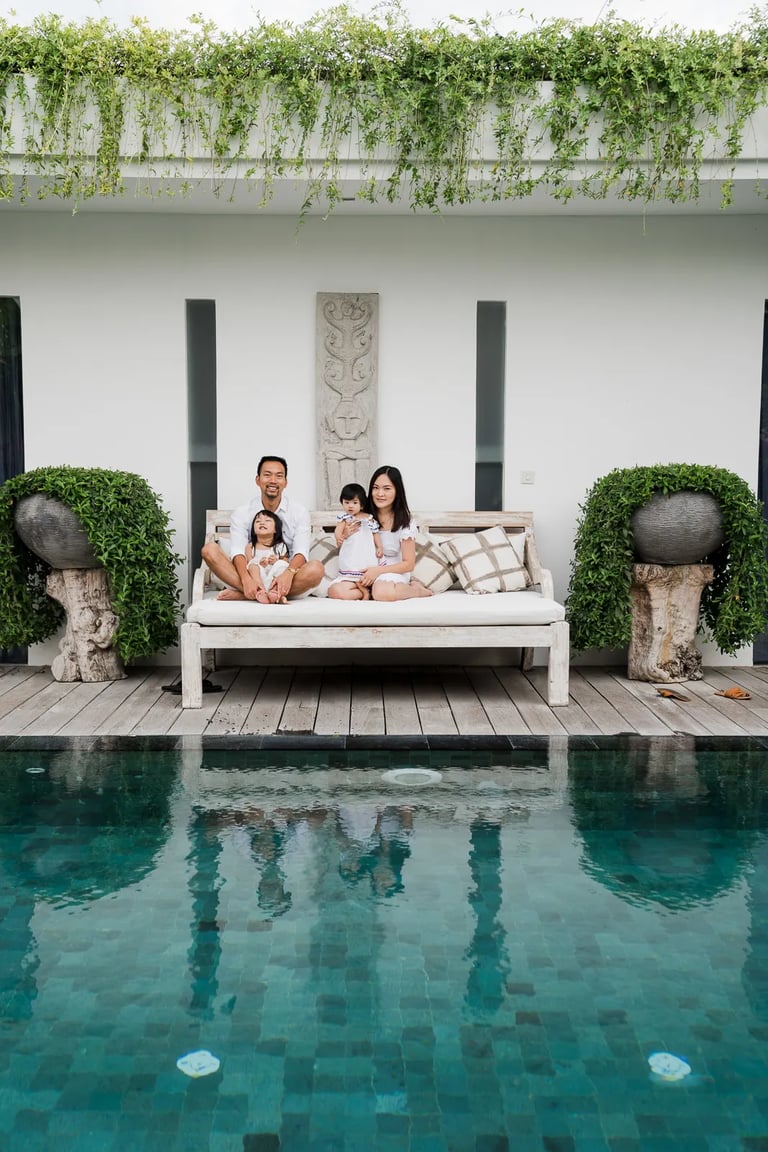 Family relaxing by the pool at a private villa in Seminyak Bali.