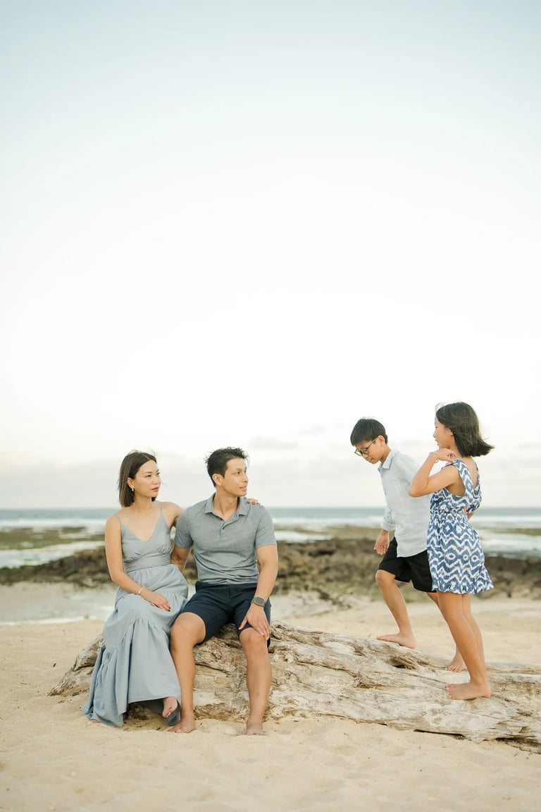 Family enjoying a candid beach moment during a luxury family photography session at The Ritz-Carlton Bali.