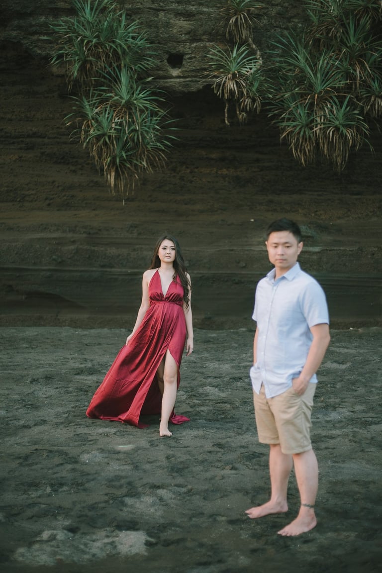 Woman walking on rock cliff during intimate couple session at Pantai Nyanyi Bali.