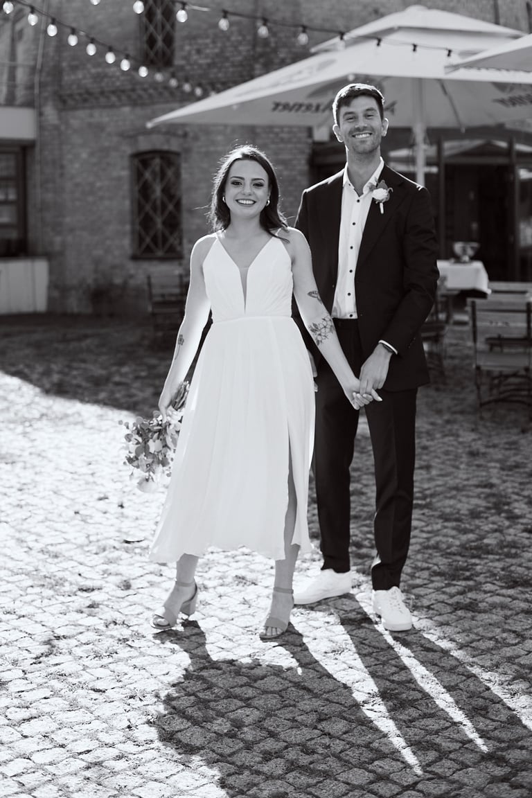 Portrait of a newlywed couple holding hands.