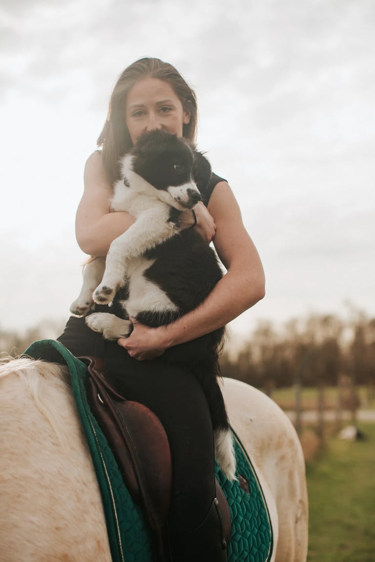 portrait d'une psychologue cavaliere avec son chiot dans les bras