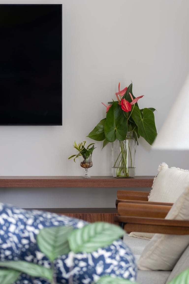 sala de tv com vaso de flores vermelhas
