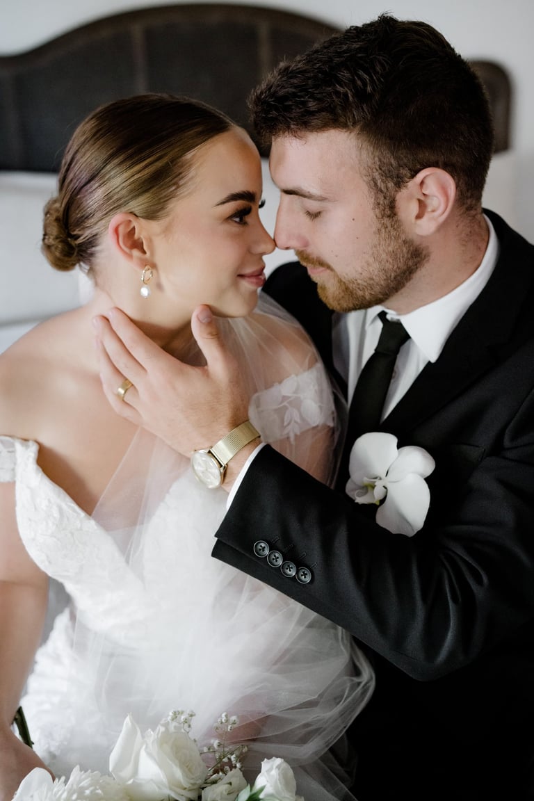 a bride and groom kissing in a hotel room