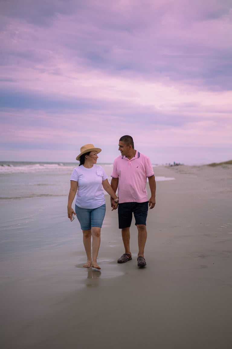 A retire couple enjoying a walk across the beach