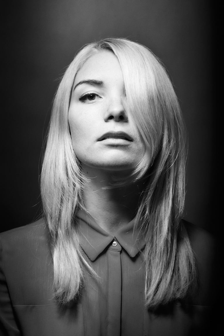 Ein schwarz-weißes Kopfbild einer jungen Frau mit blondem Haar.