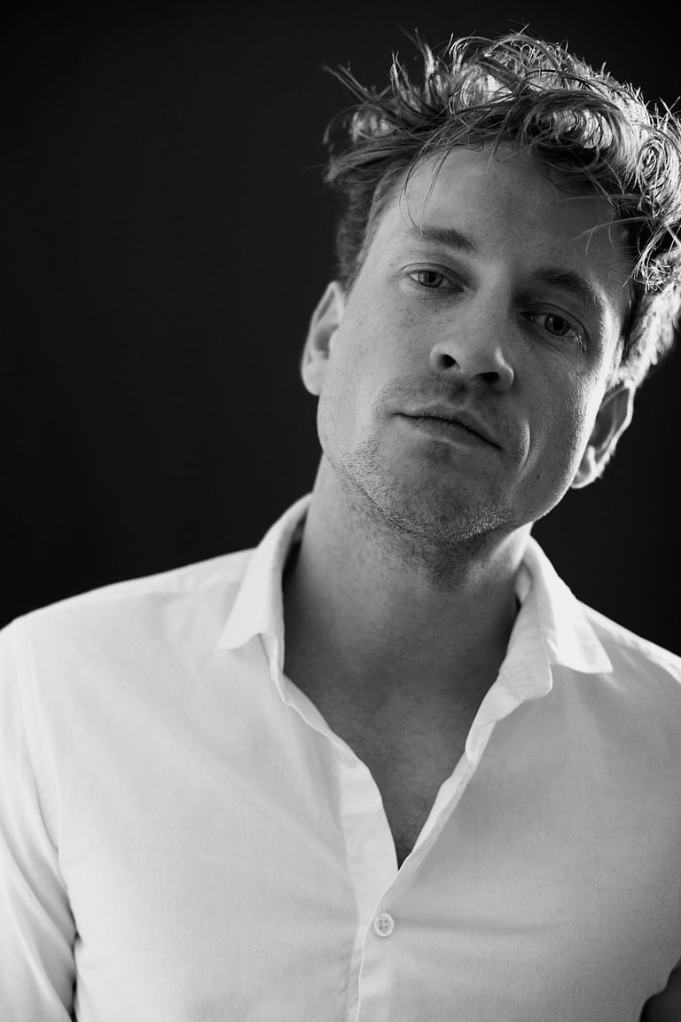 A black and white portrait of a young self-assured man.