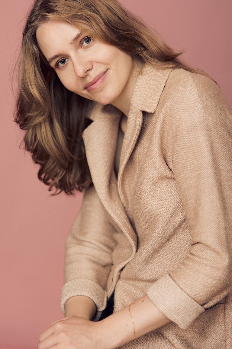 Young woman in a peach coat.