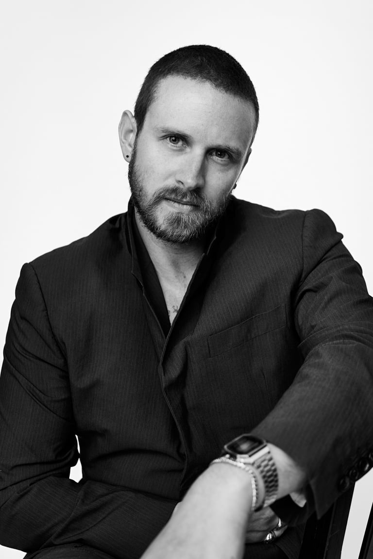 A black and white portrait of a man in a photo studio.