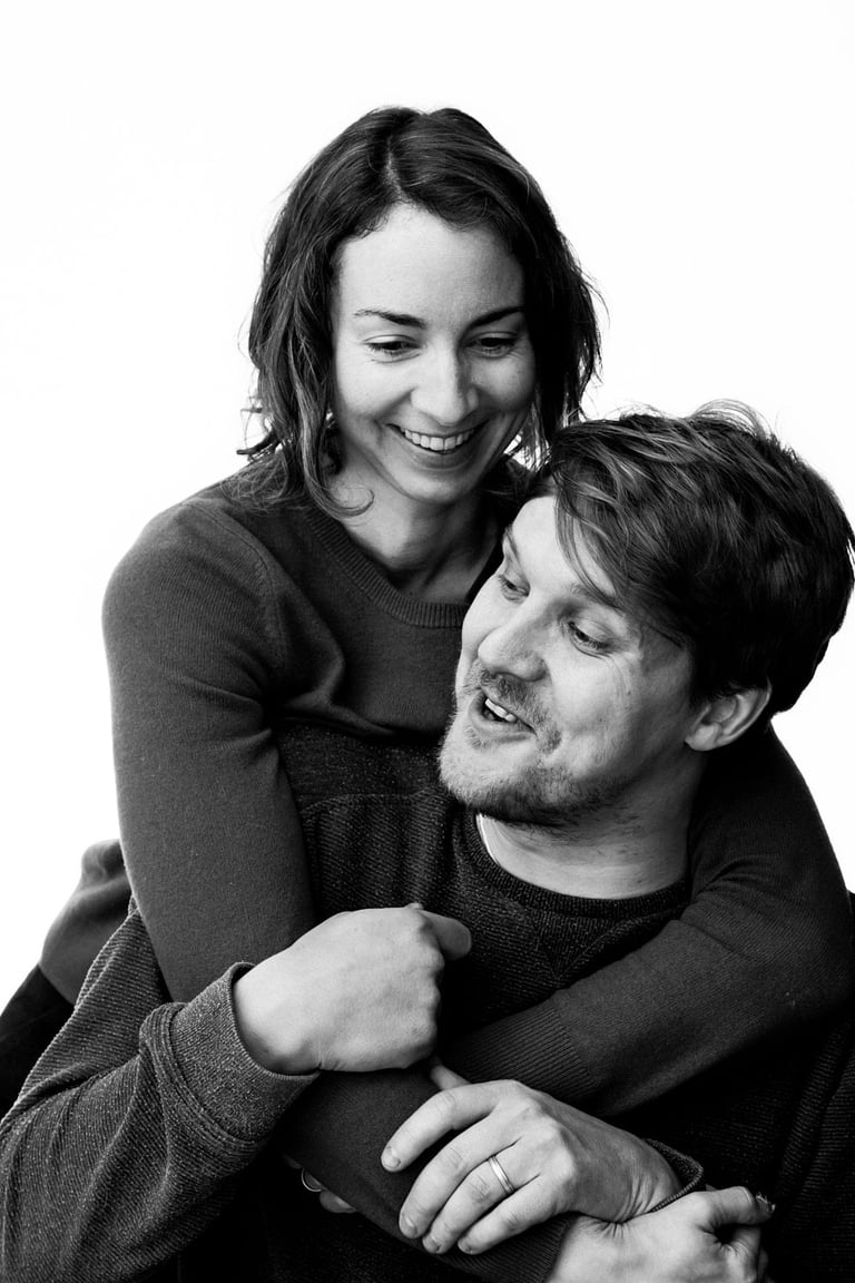 A married couple laughing during a portrait shoot.
