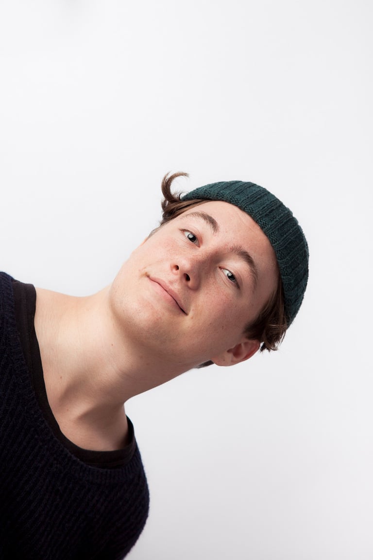 Ein junger Mann mit einem grünen Hut.