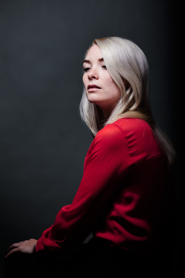 Attractive blonde woman looking down over her shoulder.