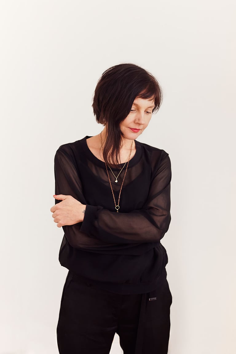 Jovanka Von Wilsdorf standing in front of a white floor wearing black clothes.