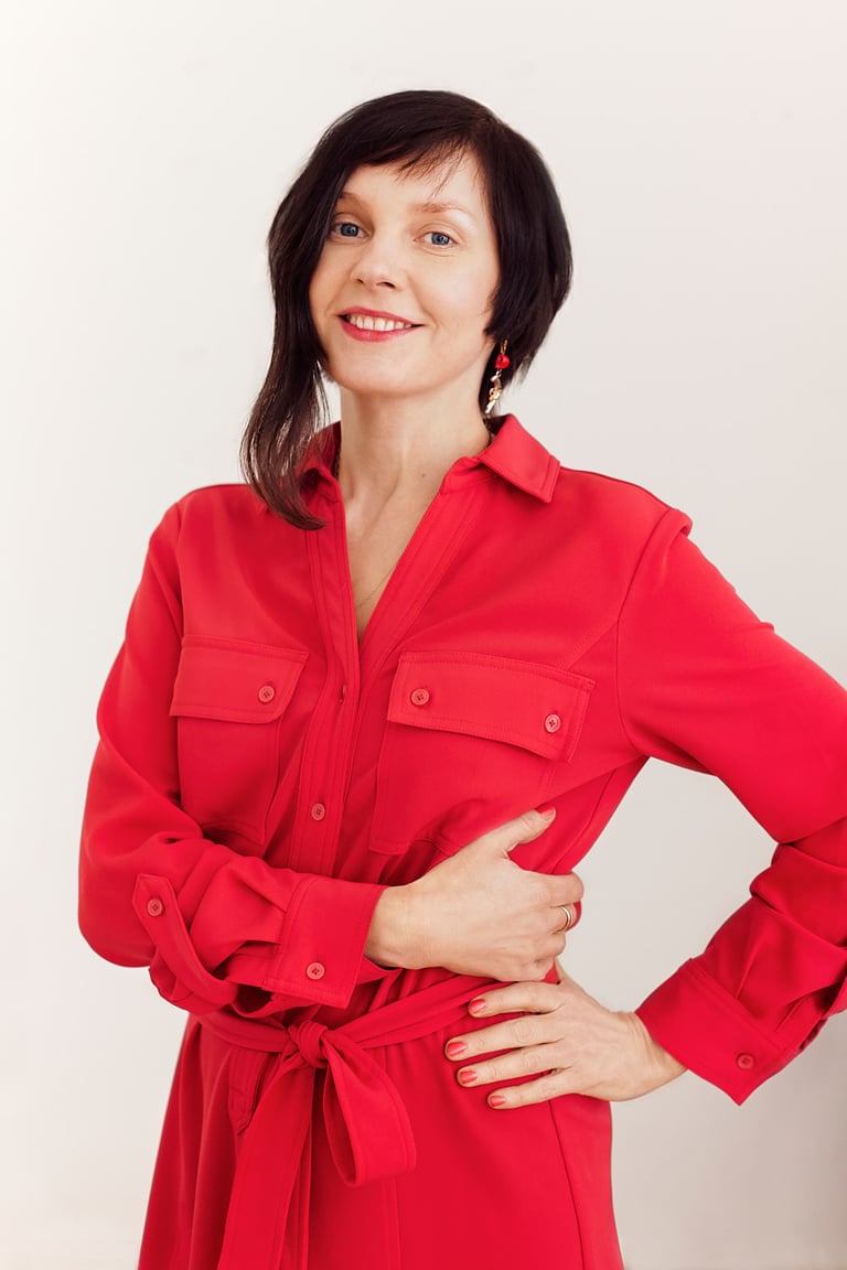 A smiling woman wearing a red dress.
