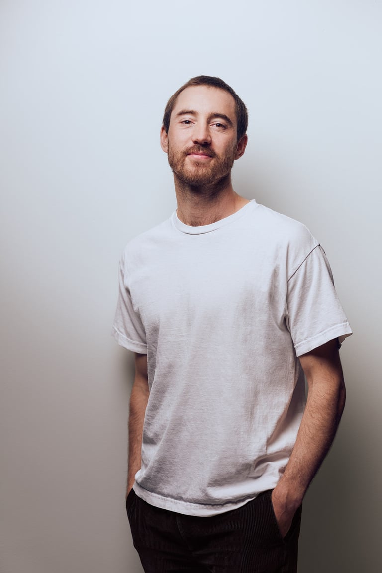 Ein Mann mit weißem Hemd, fotografiert in einem Studio.