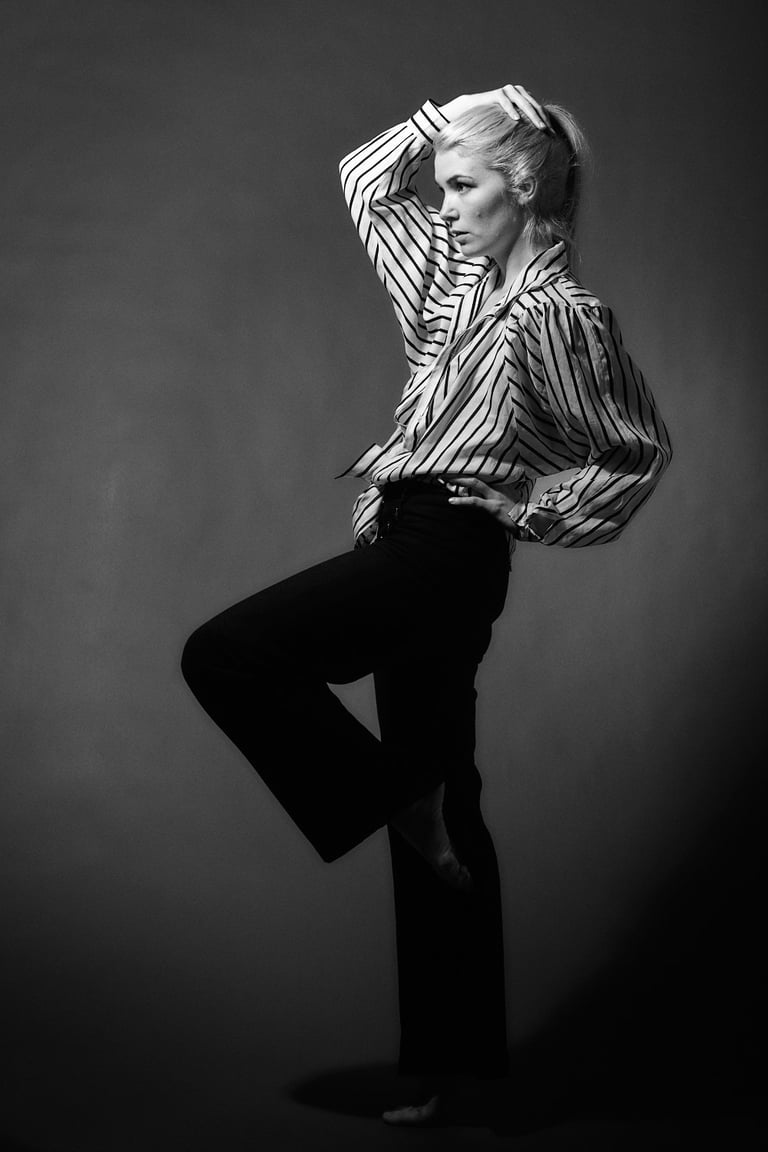 Eine junge Frau in einem Fotostudio, die eine Pose einnimmt.